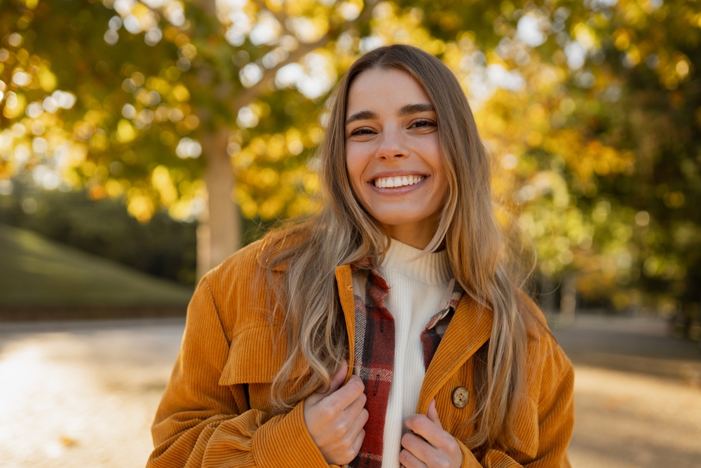 young beautiful blond woman walking in autumn park, stylish , smiling, happy mood, trendy season warm outwear, wearing velvet terracotta color jacket, student vacation